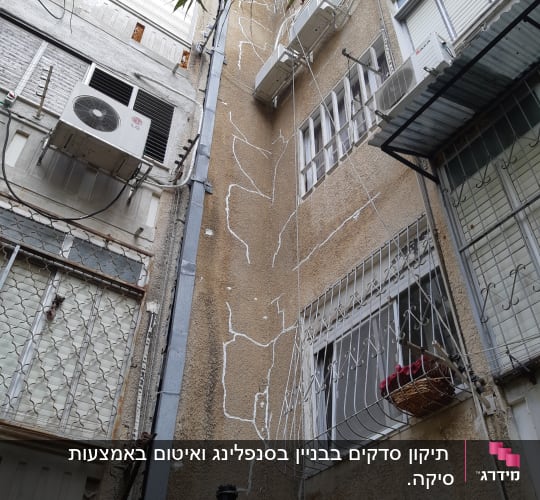קיר בניין עם סדקים ותיקונים, מזגנים מותקנים